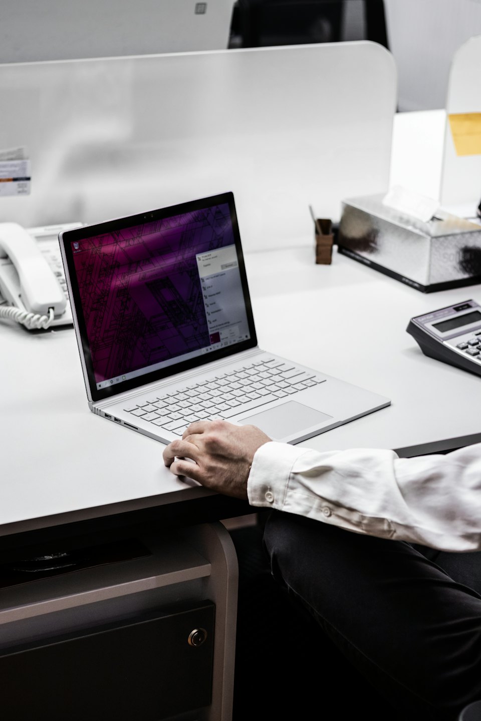 Professionnel travaillant sur un ordinateur portable à un bureau de bureau moderne.